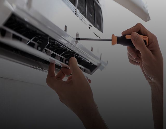 Hände, die eine Klimaanlage reparieren